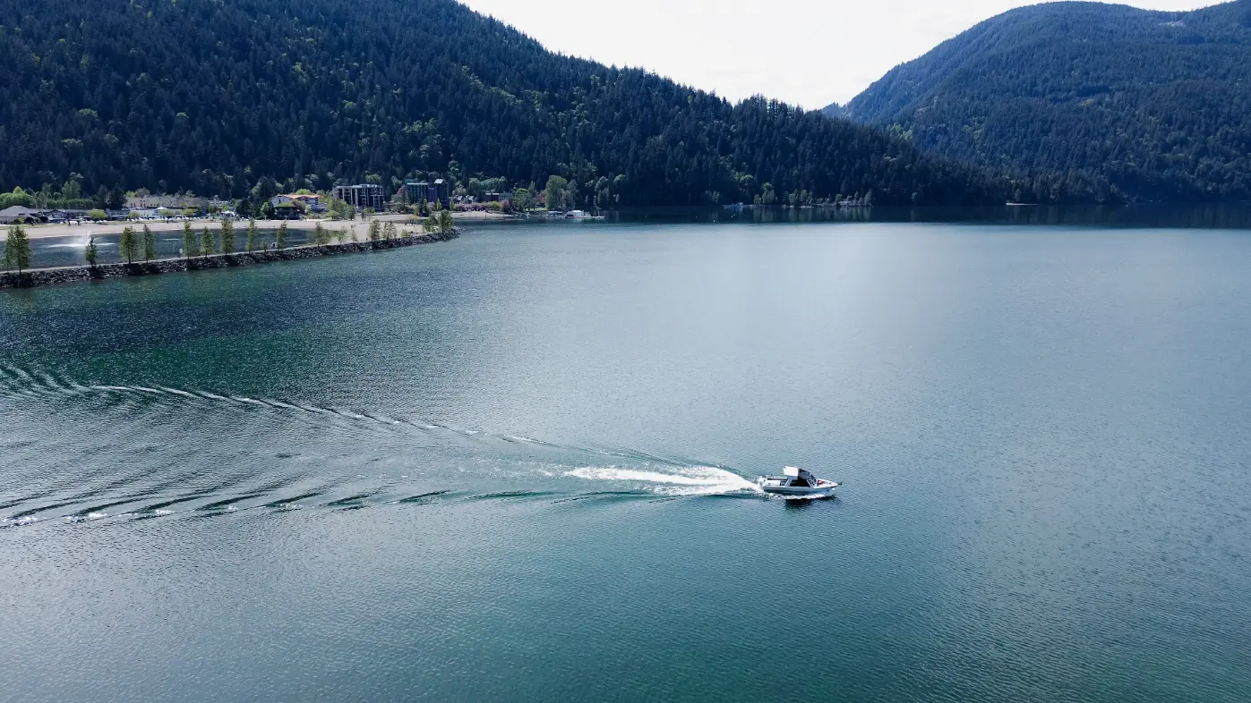 A boat speeding along the clear waters of Harrison Lake.