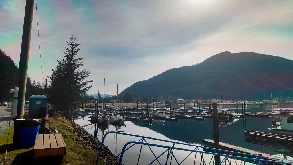 A photo of the Harrison Hot Springs Marina taken from the parking area. You can see the walkways to the docks, and the porta potties and trash bins available for members to use.